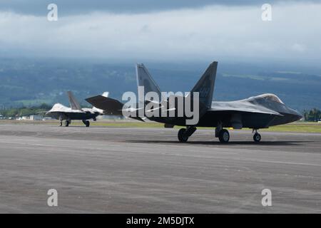 Die F-22 Raptors, die von Mitgliedern der 199. Und 19. Kampfgeschwader betrieben werden, fahren während einer Übungsübung am 4. März 2022 am Hilo International Airport, Hawaii, mit dem Taxi. Ho`oikaika wurde von totalen Streitkräften der Hawaii Air National Guard, der Nevada ANG und ihren aktiven Gegenstücken aus dem 15. Und 354. Kampfflug durchgeführt. Die Übung bot Partnereinheiten die Gelegenheit, ihre Fähigkeit zur schnellen Bereitstellung und zum Betrieb an entfernten Standorten zu demonstrieren und zu verbessern. Stockfoto